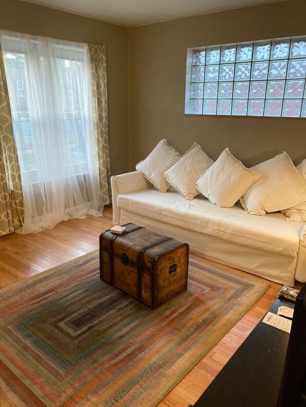 Spacious living room with fifties glass block window and sofa sleeper