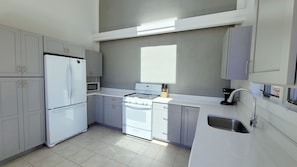 Open and bright kitchen has skylights and vaulted ceiling