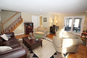 Living room with comfortable seating and doors to porch