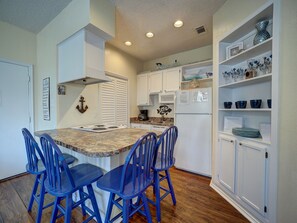 Fully equipped kitchen area with seating for four at the breakfast bar
