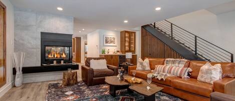 Living room with sleeper sofa, wet bar and beverage fridge, two-sided Gas Fireplace and 65" LG Smart TV