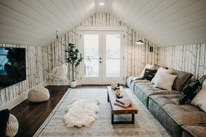 
The top-floor bonus room features an oversized sectional and wall-mounted TV, making it the perfect spot for a cozy movie night.
