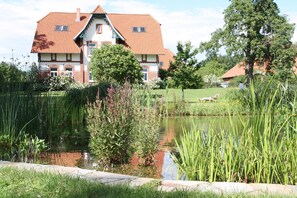 Garten. Teil des Schwimmteichs mit Jugendstilhaus im HIntergrund