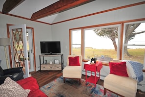 Living room w/ water views and door to screened porch