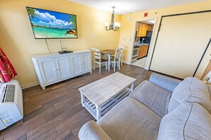 - Spacious living room with a comfortable seating area and a wall-mounted smart TV - Enjoy a meal or sip your morning coffee at the charming dining table - Steps away from the kitchen, making it easy to whip up quick meals and snacks