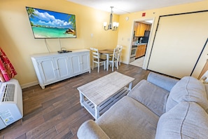 - Spacious living room with a comfortable seating area and a wall-mounted smart TV - Enjoy a meal or sip your morning coffee at the charming dining table - Steps away from the kitchen, making it easy to whip up quick meals and snacks