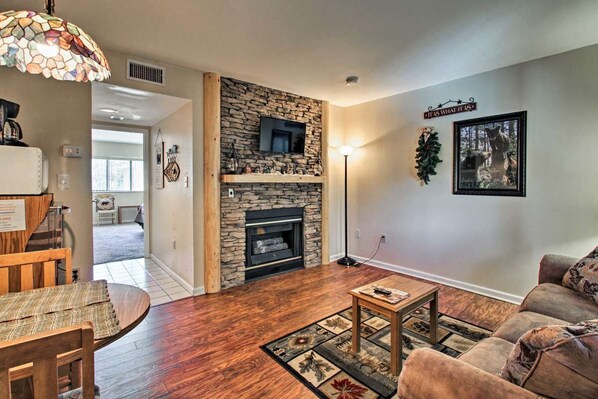 Living room with new LVP flooring and gas fireplace in winter season. Log/stone