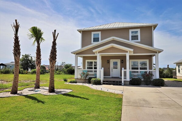 Street view of the beautiful home with mature landscaping.