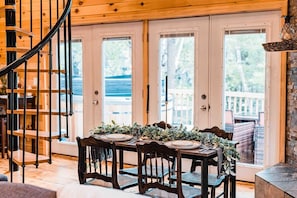 Dining area in front of the deck doors and fireplace 