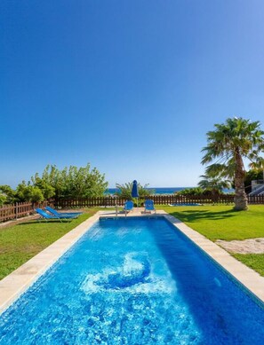 Private pool and lawn with sea views