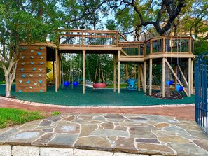 Elevated deck playground with rubber turf for safety.