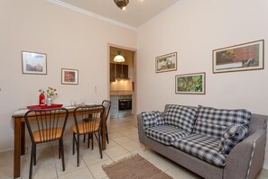 Living room with sofa, dining area, ornamental fireplace, A/C, WiFi internet, satellite TV, and DVD player