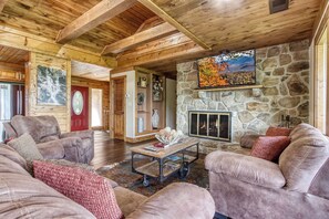 Cozy cabin charm with a stone fireplace and rustic wood beams.