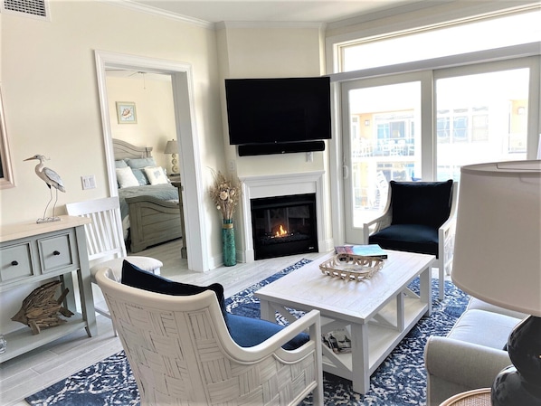 Open Living area with plenty of seating, gas fireplace & sliders lead to balcony