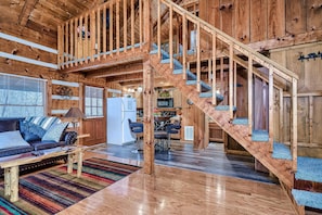 Looking through the living room toward the kitchen and loft above