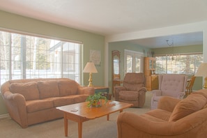 The living room has plenty of comfortable seating for everyone to enjoy
