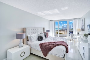 Master Bedroom, king bed, balcony access, Tv, desk, master bathroom, walk in closet with safe