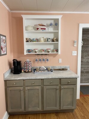 Coffee and wine bar with Keurig coffee maker and electric wine bottle opener.