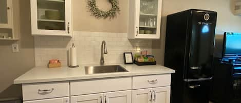 Stocked kitchen with propane stove/oven, studio size refrigerator/freezer. 