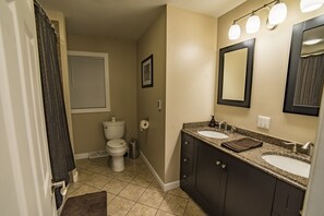 Luxurious main bathroom with granite countertops and heated tile flooring.