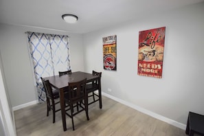 The dining area features a stylish table for four, perfect for intimate meals and cozy gatherings.