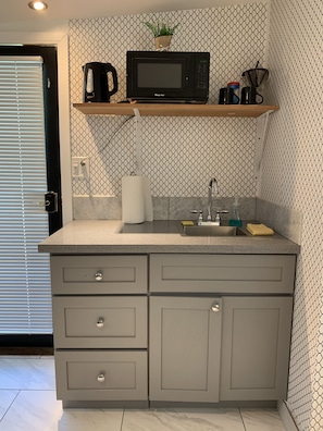 Kitchenette: sink, micro, water pot and dishes with silverware. 