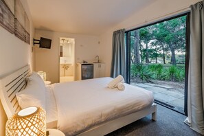 Escape to the private studio suite, where a queen-sized bed, modern ensuite, bar fridge, TV, and split-system air conditioning create a self-contained retreat.