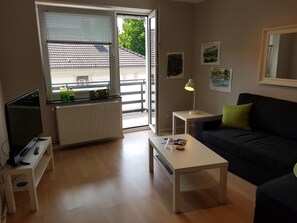 Wohnzimmer mit TV und Loggia