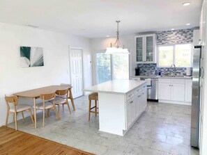 Gorgeous modern kitchen with indoor dining table and island bar stools.