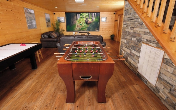 Indoor Game Room and Media Area with Big Screen TV, Foosball Table, and Air Hockey Table