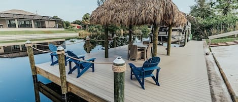 Tiki Hut on private dock with outdoor seating.