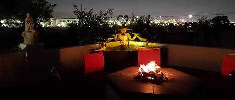 Nighttime view with fountain on and fire pit burning (propane tank is provided)