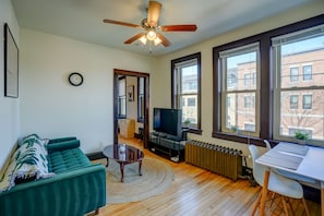 Living room with sofa, entertainment center and workspace facing Willy St