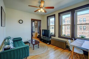 Living room with sofa, entertainment center and workspace facing Willy St