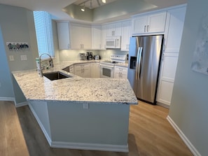 New custom white shaker cabinetry with white ice granite countertops.