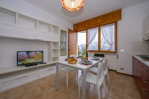 The living room with dining table and exit to the terrace