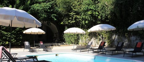 Pool with shower, lounge chairs and umbrellas