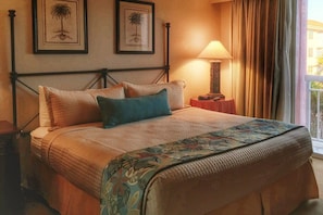Primary bedroom with a king size bed and balcony.