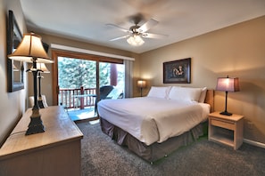 Main bedroom features a king-sized bed with white linen and a ceiling fan with light fixture