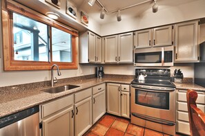 Kitchen features granite countertops, stainless steel appliances and tiled flooring