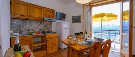 The living room with dining table and exit to the balcony