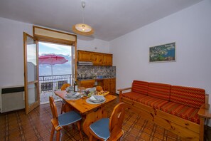 The living room with dining table and exit to the balcony