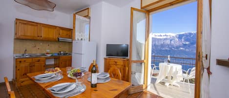 The living room with dining table and exit to the balcony