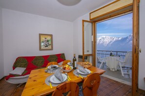 The living room with dining table and exit to the balcony