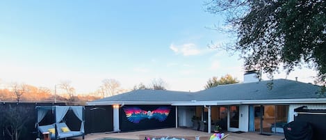 Patio with daybed, glow in dark mural, mini golf, heated pool and grill