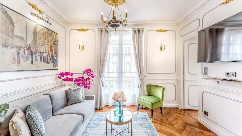 Romantic bedroom with a neutral decor, a green chair and some pink flowers