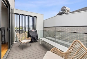 Private patio deck has outdoor furniture and a BBQ.