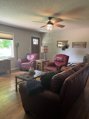 Living room with seating and optional electric queen inflatable mattress.