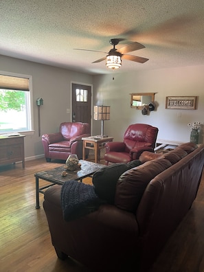 Living room with seating and optional electric queen inflatable mattress.