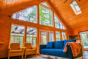 The Great Room with the view of the outdoors through large windows and skylights